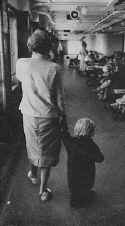 Ile de France. Swathed in a sweater donated by a sailor, a small child clings to her mother's hand. Photo: Loomis Dean